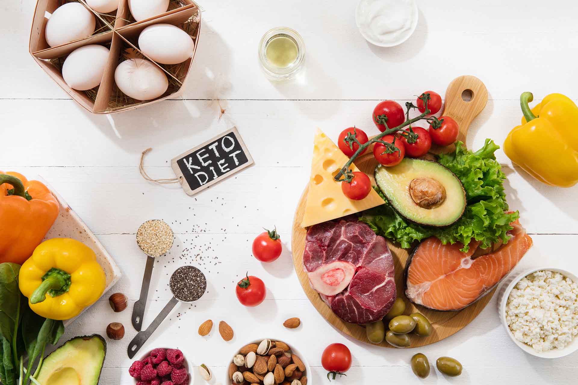 Ketogenic low carbs diet - food selection on white wooden background. Balanced healthy organic ingredients of high content of fats. Nutrition for the heart and blood vessels. Meat, fish and vegetables.